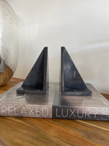 Decorative shelf with 'Relaxed Luxury' text on a wooden surface.