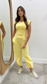 Woman in a yellow outfit standing in front of a mirror.
