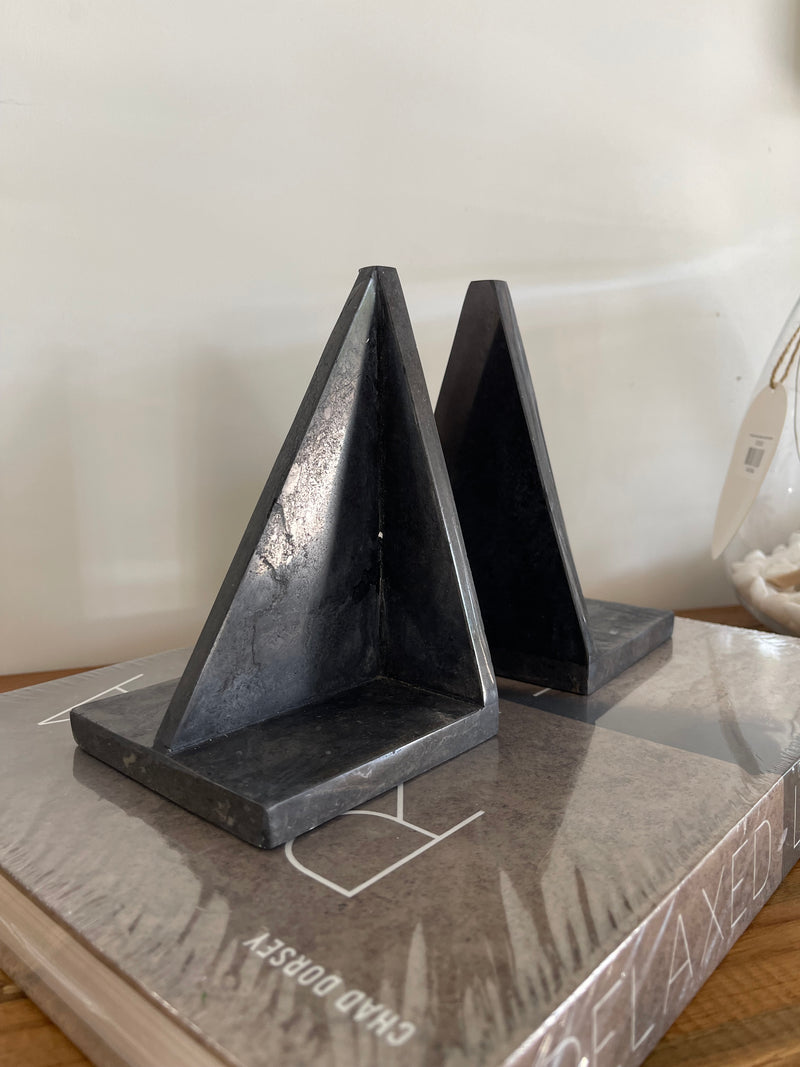 Black metal bracket on a white surface with a blurred background